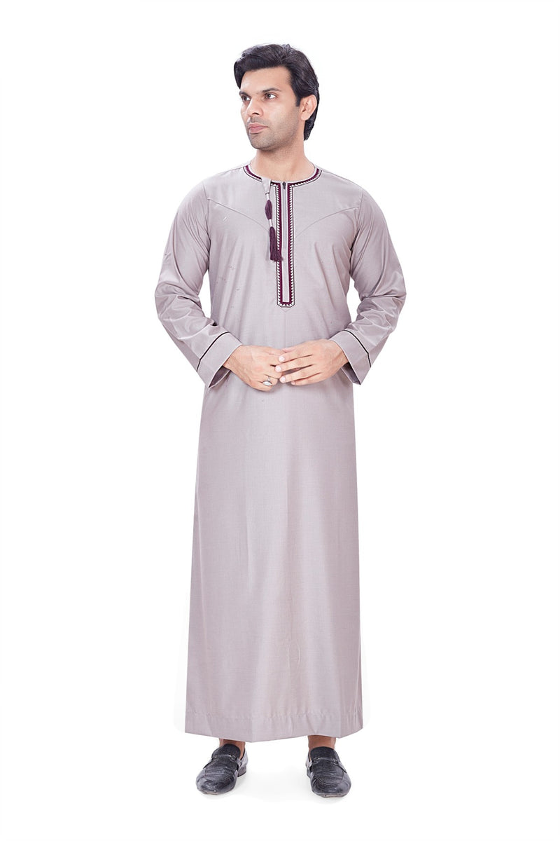 Light grey Omani Thobe featuring navy blue machine embroidery and a detachable tassel By Zamzam